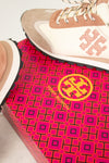Tory Burch sneaker on a pink and black patterned mat