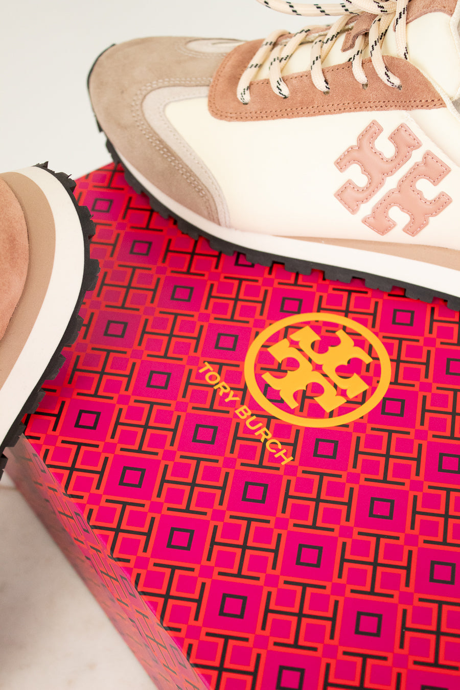 Tory Burch sneaker on a pink and black patterned mat