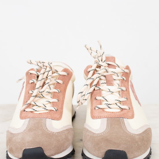 Pair of beige and pink high-top sneakers on a light background