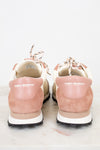 Pink sneakers with white soles and 'Tory Burch' branding on a light background