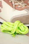 Close-up of green shoelaces on a sneaker with a blurred background