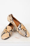 A pair of Tory Burch snakeskin loafers with gold-tone metal logo hardware, displayed on a light marble surface against a white background.