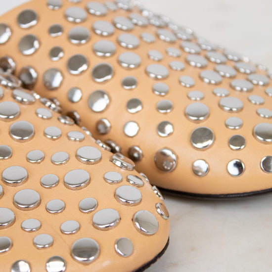 Beige shoes with silver studs on a light background