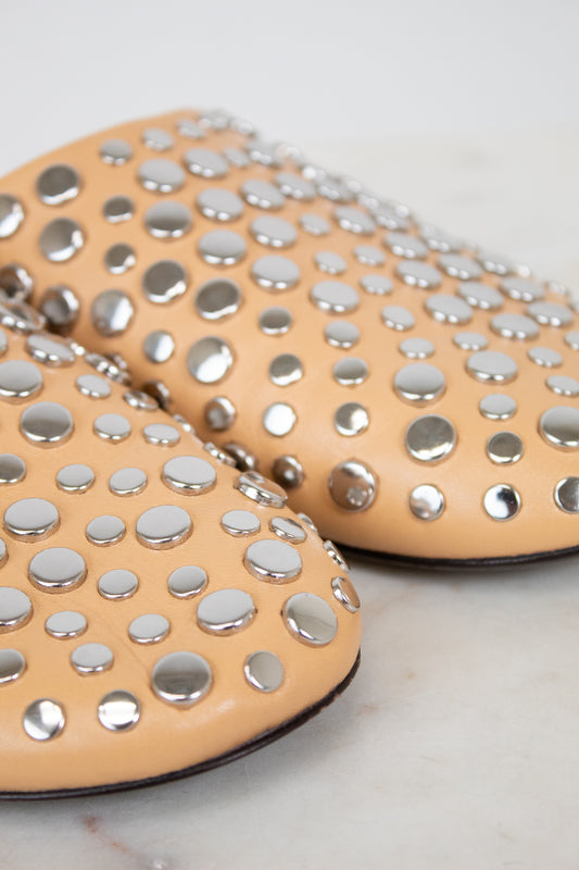 Beige shoes with silver studs on a light background