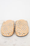 Pair of beige slippers with silver studs on a white background