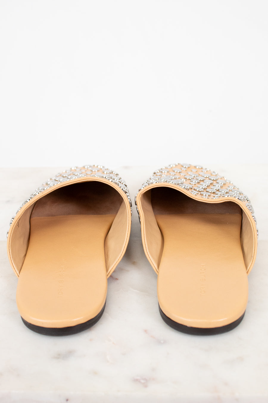 Pair of embellished slippers on a white background