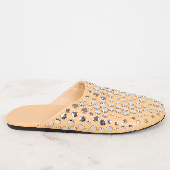 Beige slipper with studded embellishments on a white background