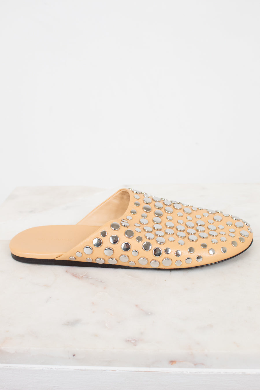 Beige slipper with studded embellishments on a white background