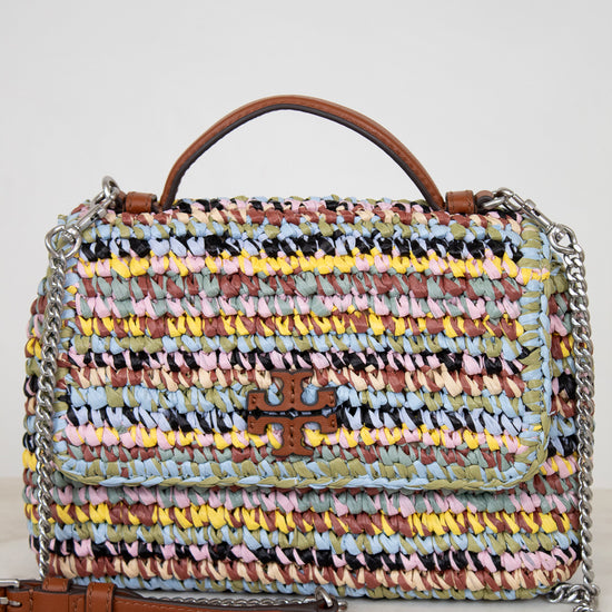 Multicolored woven handbag with a brown Tory Burch logo and chain detail on a light background