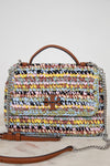 Multicolored woven handbag with a brown Tory Burch logo and chain detail on a light background