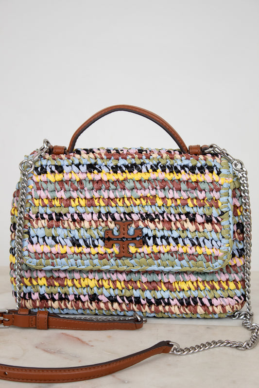 Multicolored woven handbag with a brown Tory Burch logo and chain detail on a light background