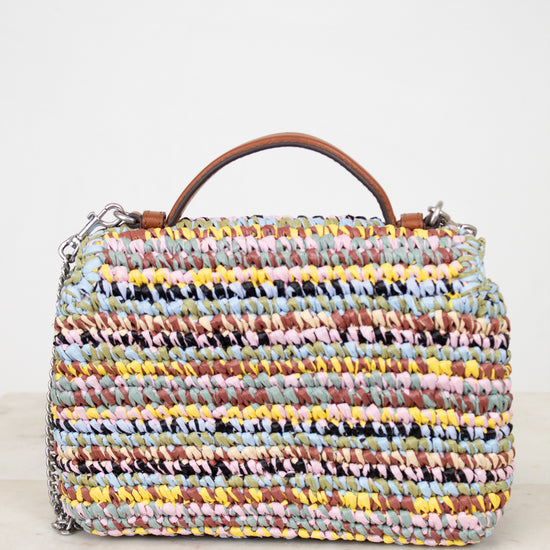 Multicolored woven handbag with a brown handle on a light background