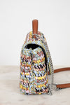 Multicolored woven handbag with a chain detail on a light background