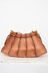 Tan leather handbag with drawstring on a white background