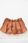 Brown leather handbag with drawstring on a white background