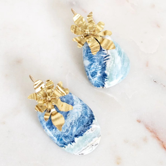 Blue and gold earrings on a light background