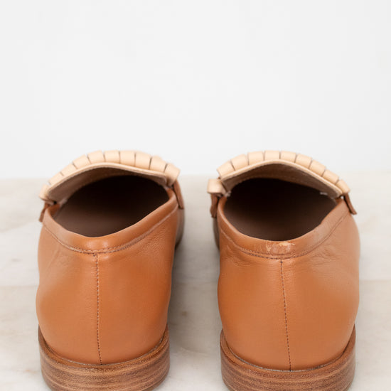 Pair of tan leather shoes on a light gray background