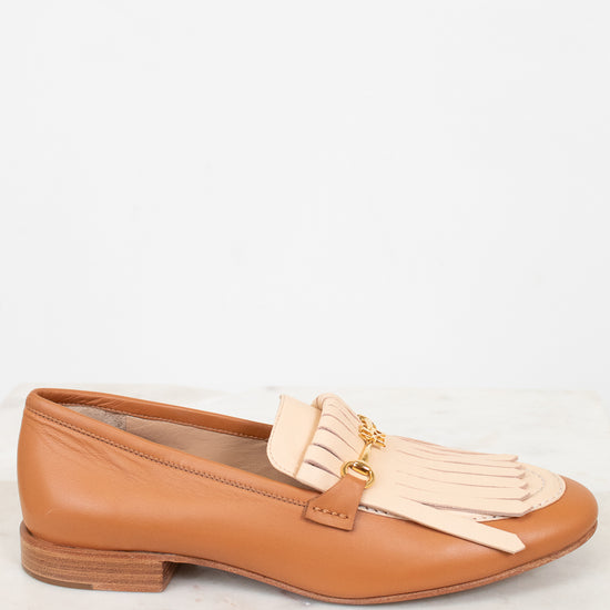 Tan loafer with beige tassel on a white background