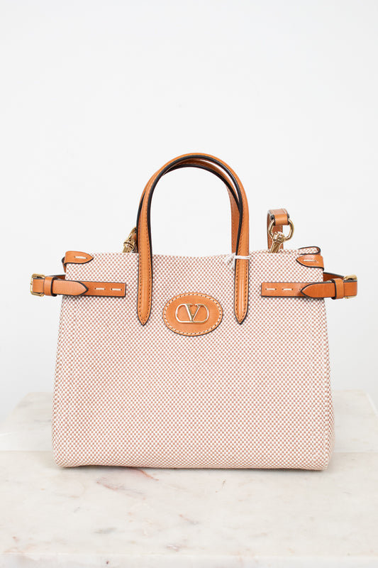 Beige handbag with brown handles and accents on a light gray background