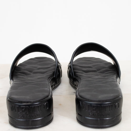 Black sandals with a Valentino brand logo on a white background