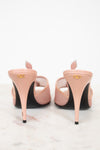 Pair of pink high-heeled shoes with black soles on a white background