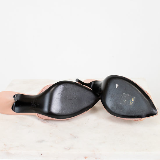 Black soles of high heeled shoes on a white background