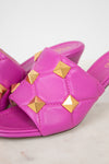 Pink sandals with gold studs on a light background