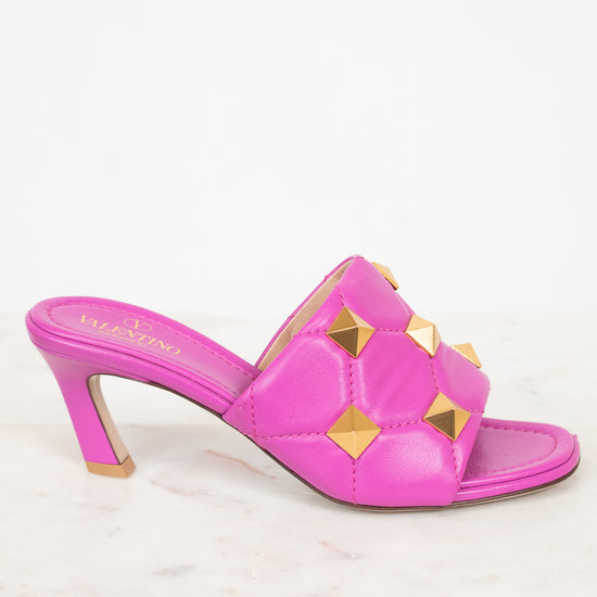 Pink heeled sandal with gold accents on a white background