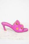 Pink heeled sandal with gold accents on a white background