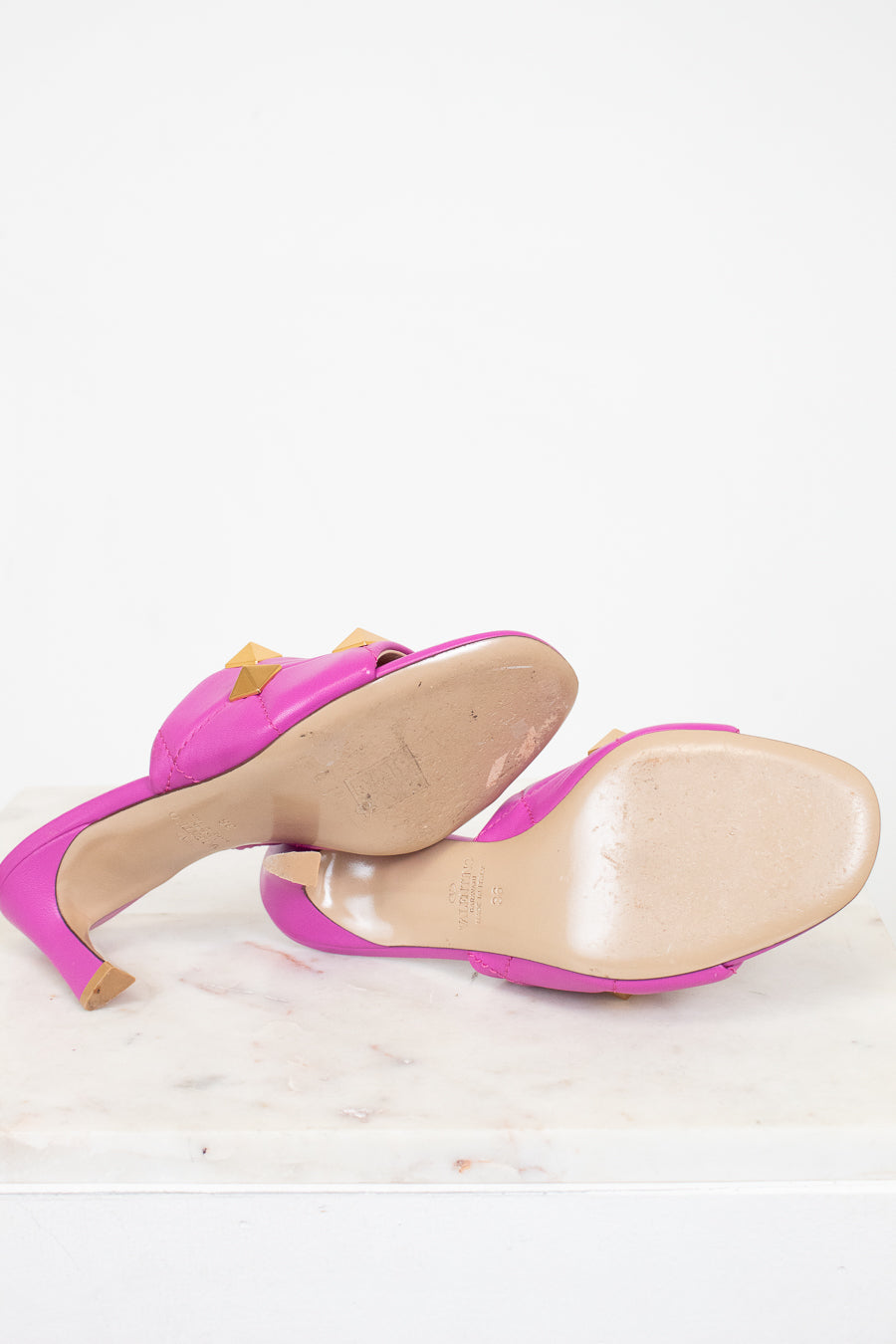 Pair of pink heeled sandals on a white background
