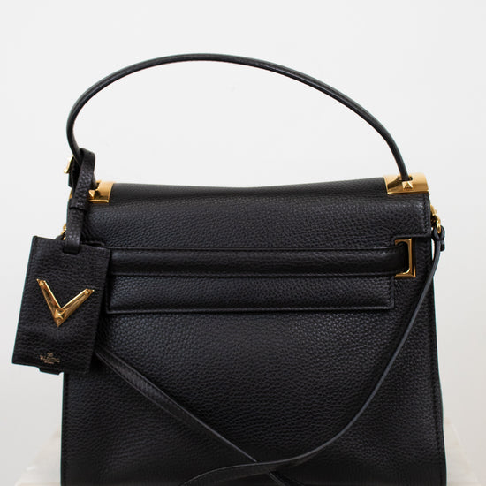 Black handbag with gold accents on a white background