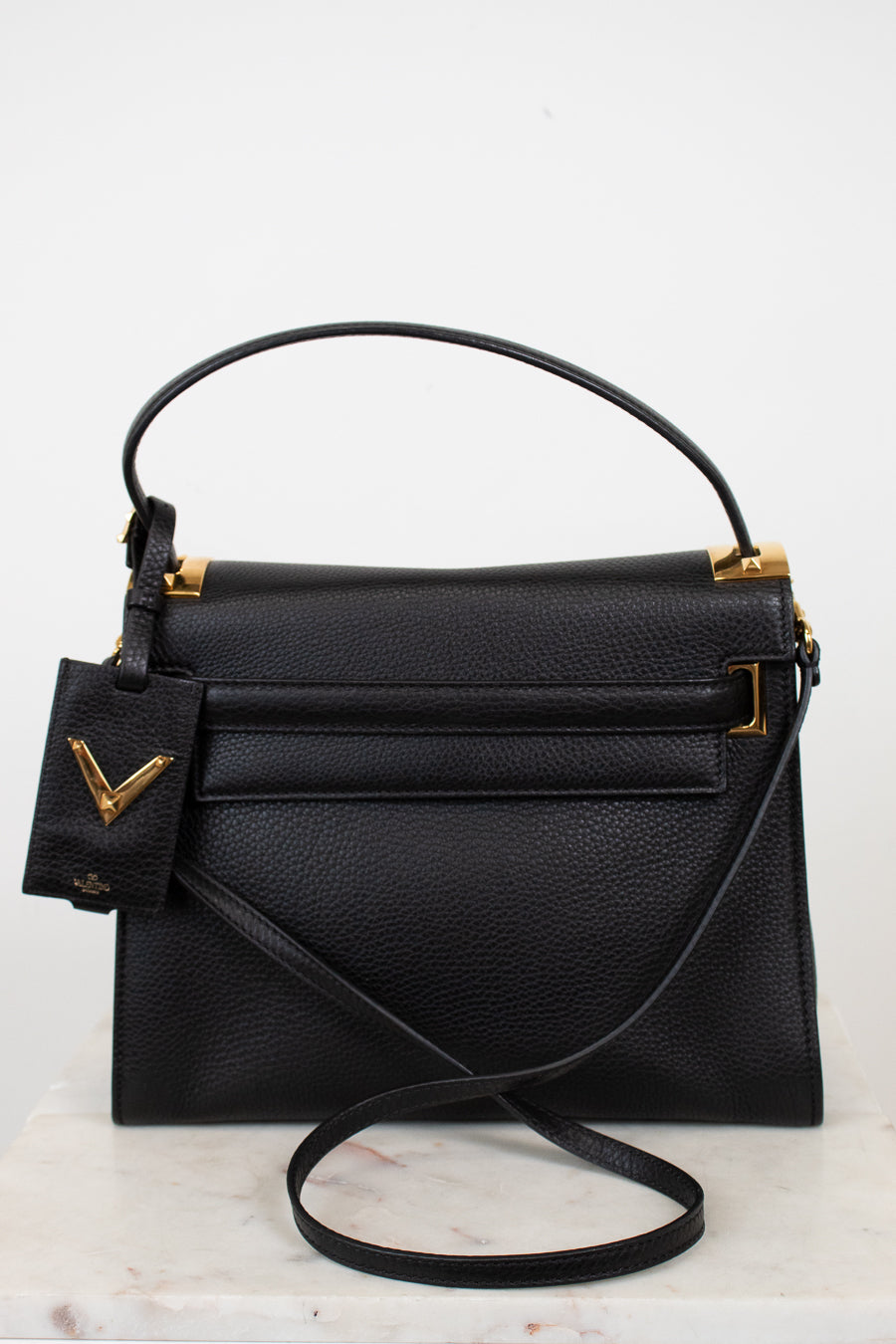 Black handbag with gold accents on a white background