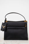Black handbag with gold accents on a light background