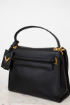 Black handbag with gold accents on a light gray background