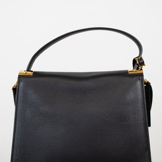 Black handbag with gold accents on a white background