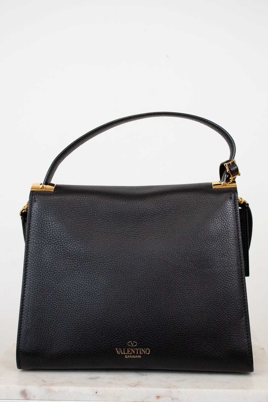 Black handbag with gold accents on a white background