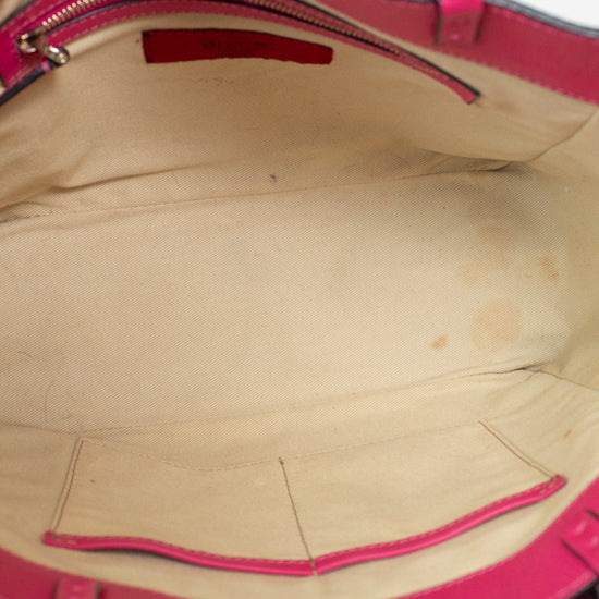 Close-up of a pink handbag with visible wear on the interior.