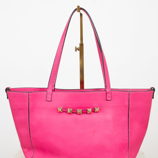 Pink handbag with gold accents on a white background