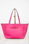 Pink handbag with gold accents on a white background