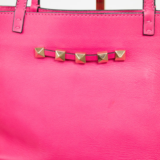 Pink handbag with gold stud details on a light background