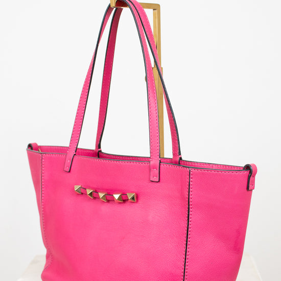 Pink tote bag with gold accents on a white background