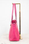 Pink handbag on a gold stand against a white background
