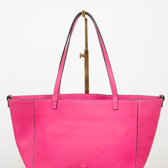 Pink handbag with a visible brand logo on a white background