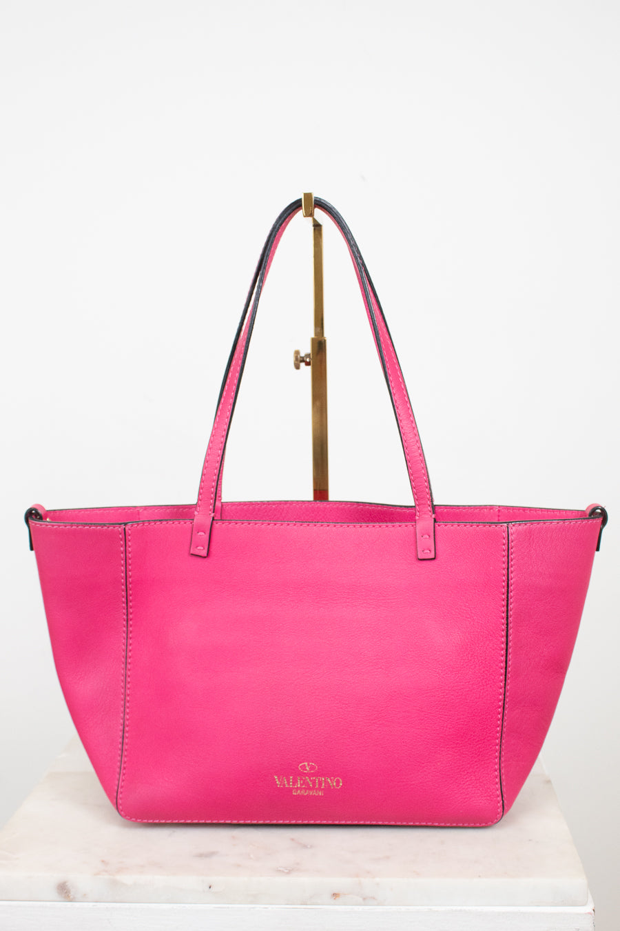 Pink handbag with a visible brand logo on a white background