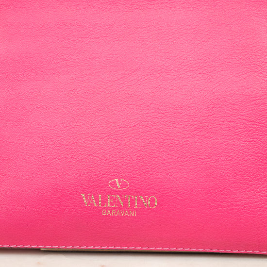 Pink leather handbag with Valentino logo on a light marble surface