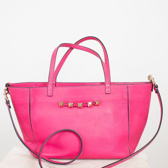 Pink handbag with gold accents on a white background