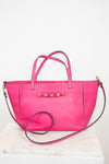 Pink handbag with gold accents on a white background