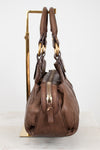 Brown handbag with gold accents on a white background