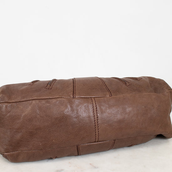 Brown leather bag on a white marble surface
