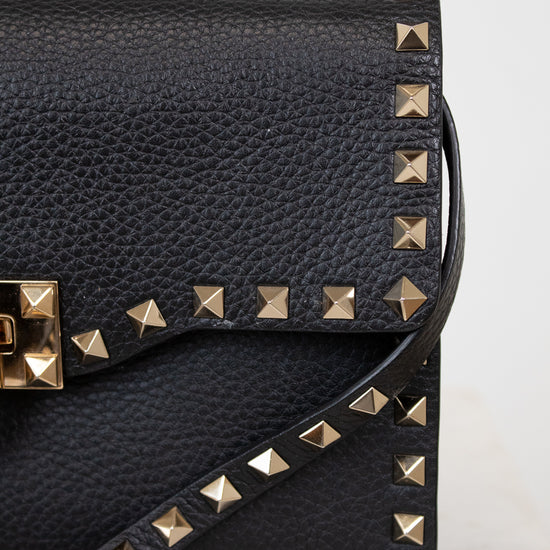 Black studded handbag on a light gray background